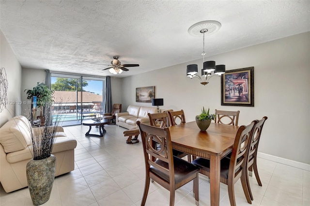 dining room with a textured ceiling, ceiling fan with notable chandelier, light tile patterned floors, and floor to ceiling windows