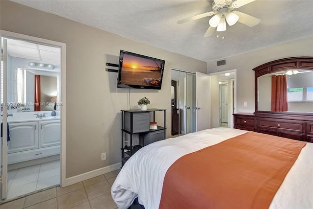 tiled bedroom with ceiling fan, connected bathroom, and a closet