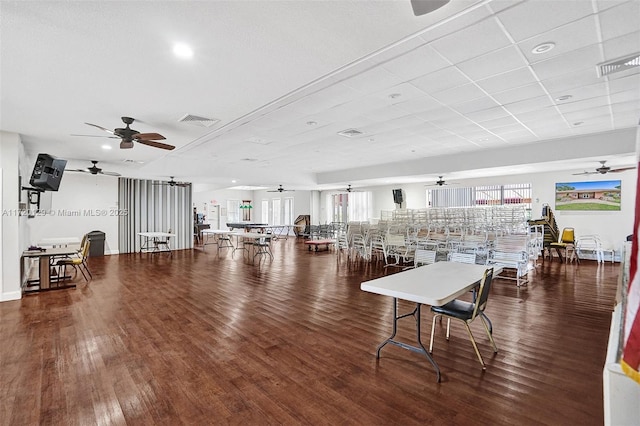 interior space featuring a drop ceiling, dark hardwood / wood-style floors, and ceiling fan