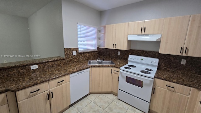 kitchen featuring light brown cabinetry, white appliances, sink, light tile patterned floors, and dark stone countertops