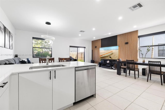 kitchen with dishwasher, sink, light tile patterned floors, pendant lighting, and white cabinets