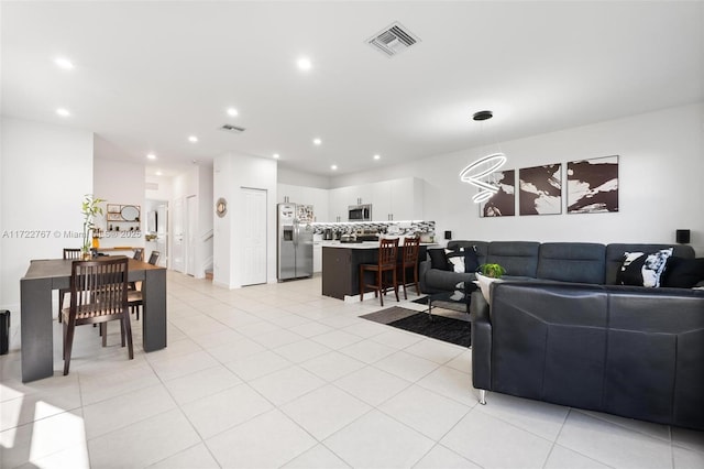 tiled living room featuring a notable chandelier