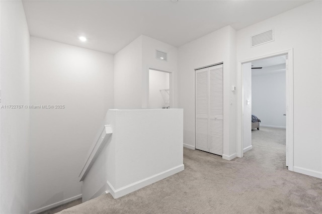 hallway featuring light colored carpet