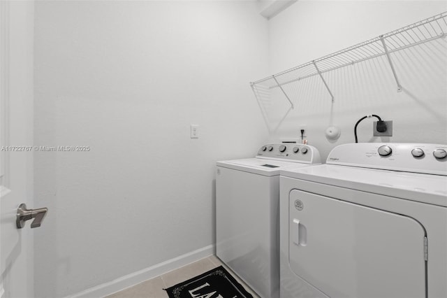 laundry room featuring washing machine and clothes dryer and tile patterned flooring