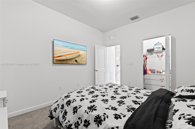 carpeted bedroom with a walk in closet and a closet