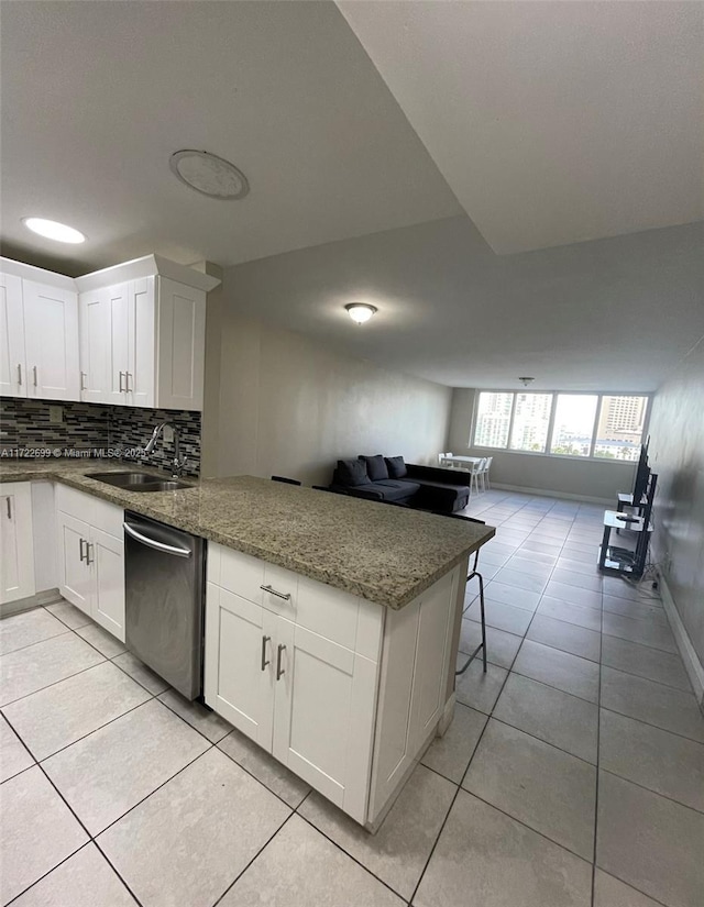 kitchen featuring kitchen peninsula, sink, dark stone countertops, dishwasher, and white cabinetry