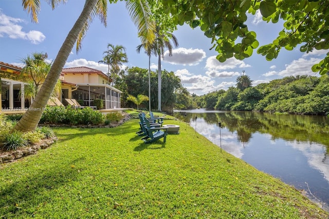 surrounding community with a water view and a yard