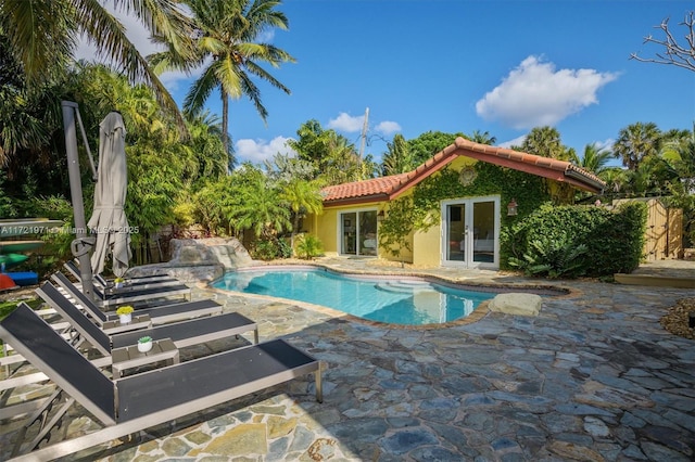 view of swimming pool with an outbuilding, french doors, and a patio