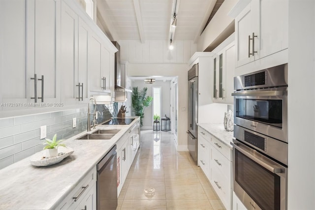 kitchen with wood ceiling, stainless steel appliances, beamed ceiling, white cabinets, and sink