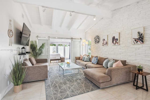 living room with light tile patterned flooring, rail lighting, a barn door, and vaulted ceiling with beams