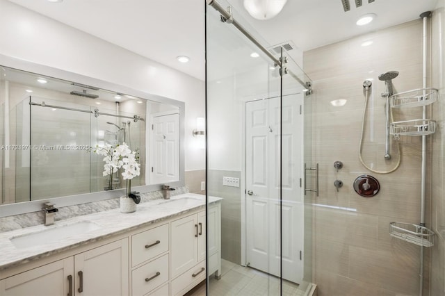 bathroom featuring a shower with shower door and vanity