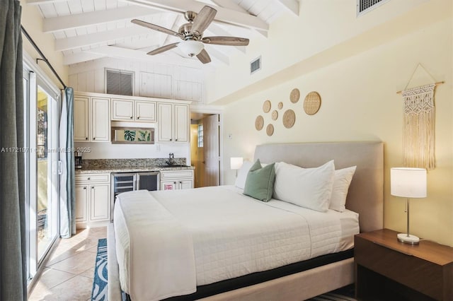 tiled bedroom with ceiling fan, multiple windows, access to outside, and vaulted ceiling with beams