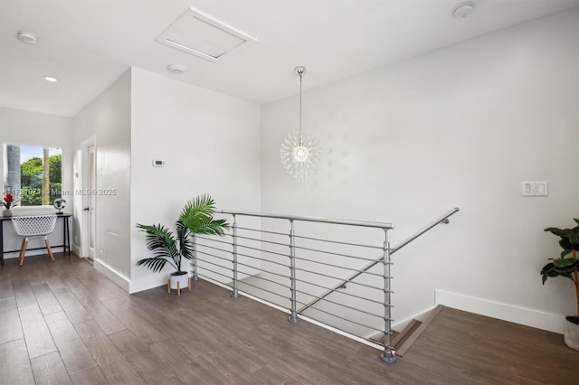 hallway featuring dark wood-type flooring and an inviting chandelier