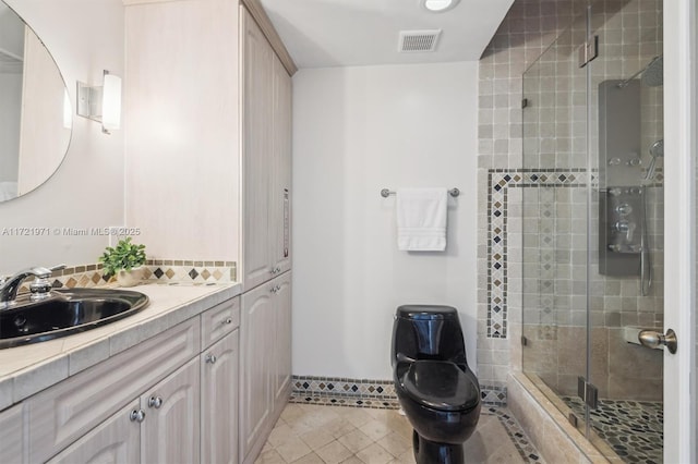 bathroom with walk in shower, vanity, tile patterned flooring, and toilet