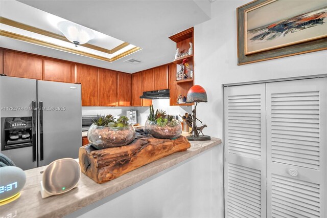 kitchen with exhaust hood and stainless steel fridge