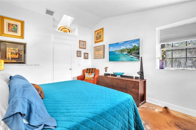 bedroom featuring lofted ceiling and hardwood / wood-style floors