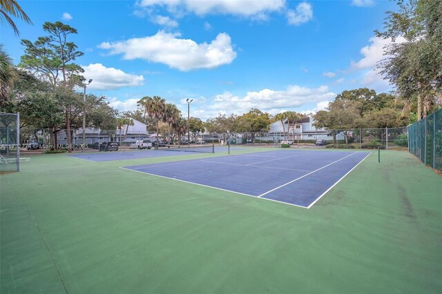 view of tennis court featuring basketball hoop