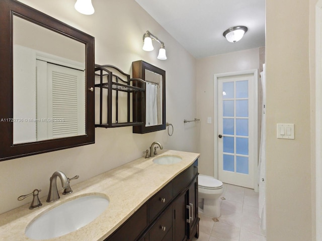 bathroom with tile patterned flooring, vanity, and toilet