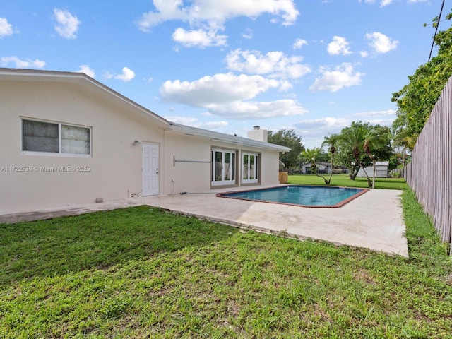 view of swimming pool featuring a patio and a lawn