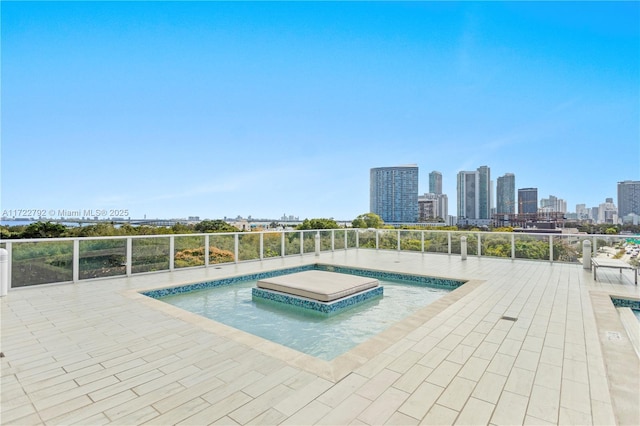 view of swimming pool featuring a jacuzzi and a patio