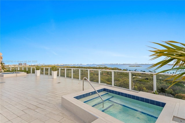 view of swimming pool with an in ground hot tub and a water view