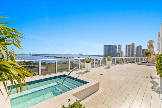 view of pool featuring a water view and a hot tub