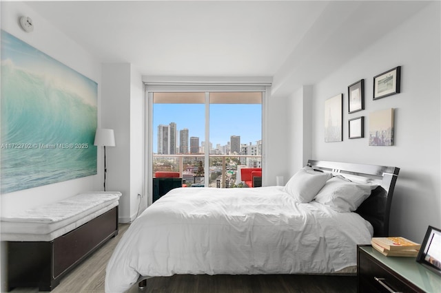 bedroom with floor to ceiling windows and light hardwood / wood-style floors