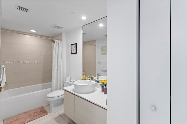 full bathroom featuring tile patterned floors, shower / bath combo with shower curtain, vanity, and toilet