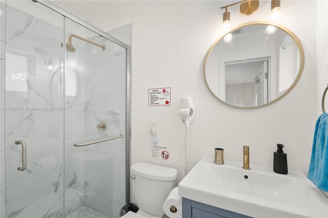 bathroom with vanity, toilet, and a shower with door