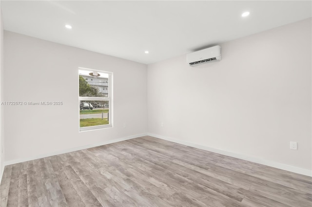 empty room with light hardwood / wood-style floors and a wall mounted AC