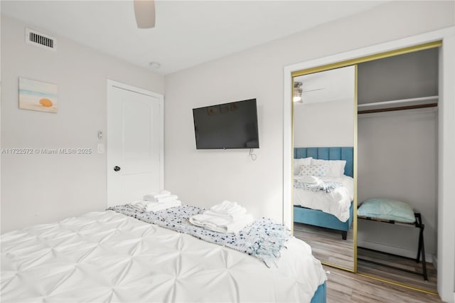 bedroom with ceiling fan, a closet, and wood-type flooring