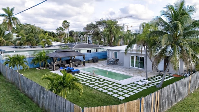 view of swimming pool featuring a lawn, a hot tub, an outdoor living space with a fire pit, a gazebo, and a patio