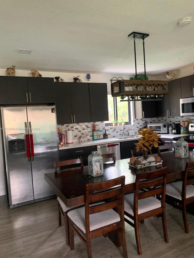 kitchen featuring decorative backsplash, sink, appliances with stainless steel finishes, and dark wood-type flooring