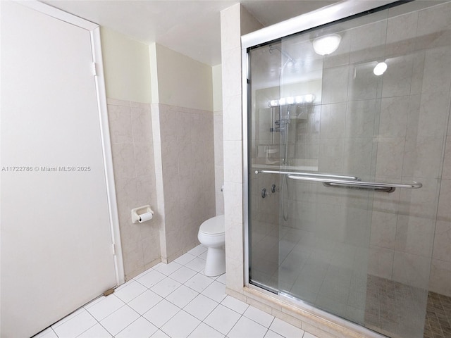 bathroom with walk in shower, tile walls, tile patterned floors, and toilet