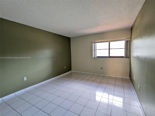 tiled spare room with a textured ceiling