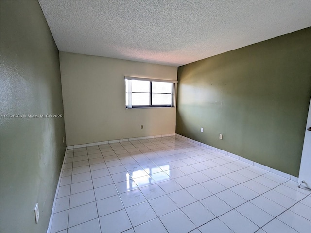 empty room featuring light tile patterned flooring and a textured ceiling