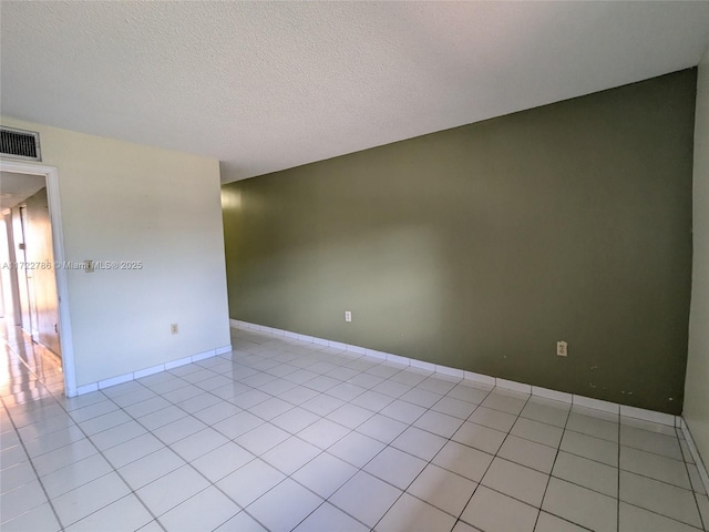 unfurnished room with light tile patterned flooring and a textured ceiling