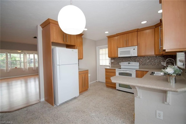 kitchen with white appliances, sink, hanging light fixtures, tasteful backsplash, and a healthy amount of sunlight