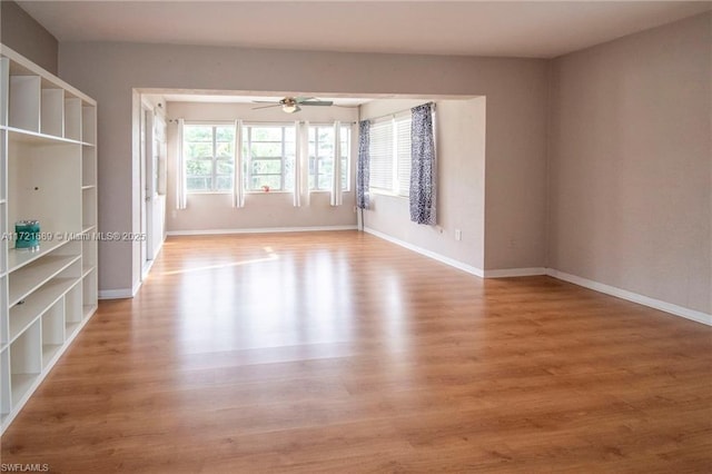 empty room with hardwood / wood-style floors and ceiling fan