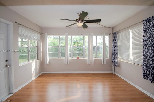 unfurnished sunroom featuring a wealth of natural light and ceiling fan