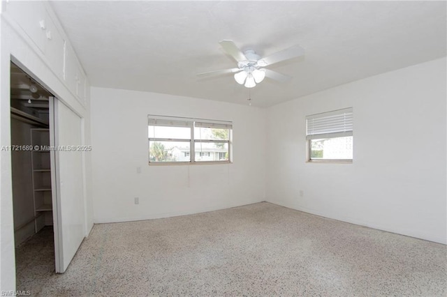 unfurnished bedroom featuring ceiling fan and a closet