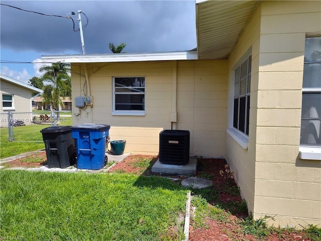 view of property exterior with a yard and central air condition unit