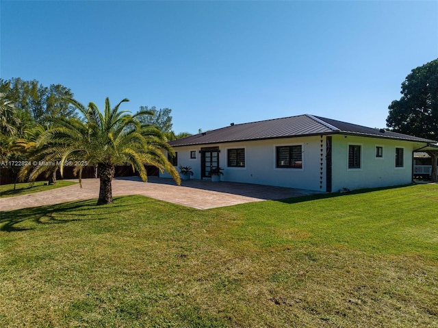 rear view of property featuring a lawn and a patio