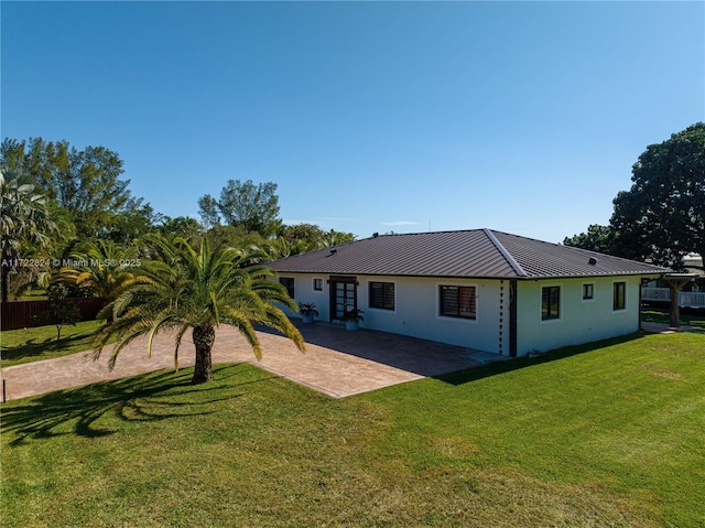 back of property with a yard and a patio