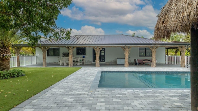 back of property with a yard and a patio