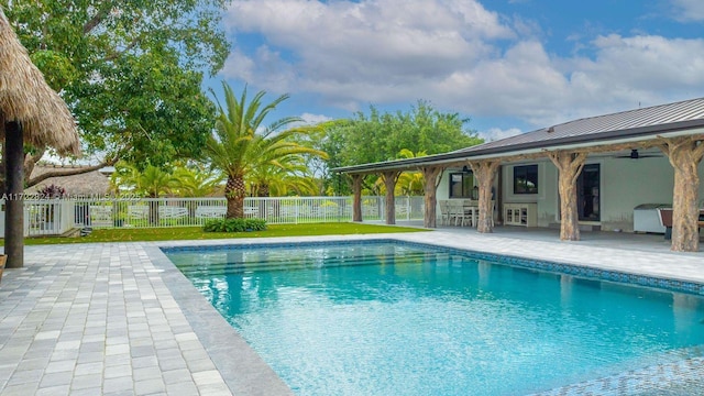 view of swimming pool featuring a patio area, ceiling fan, and area for grilling