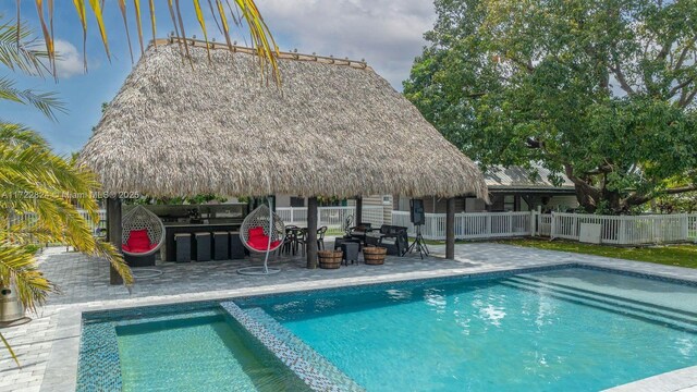 view of swimming pool with a gazebo, a patio area, and a bar