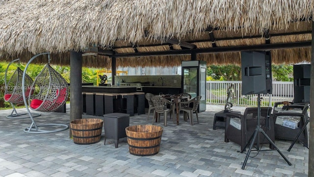 view of patio / terrace with a gazebo, a bar, and an outdoor kitchen