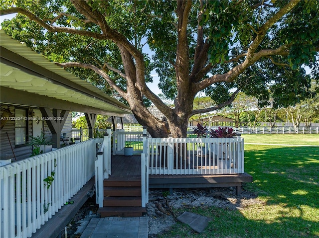 wooden deck featuring a lawn