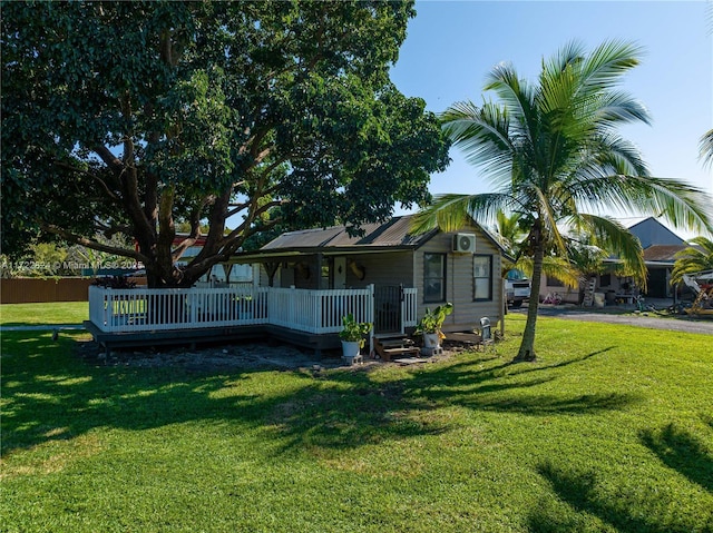 rear view of house with a lawn and a wooden deck